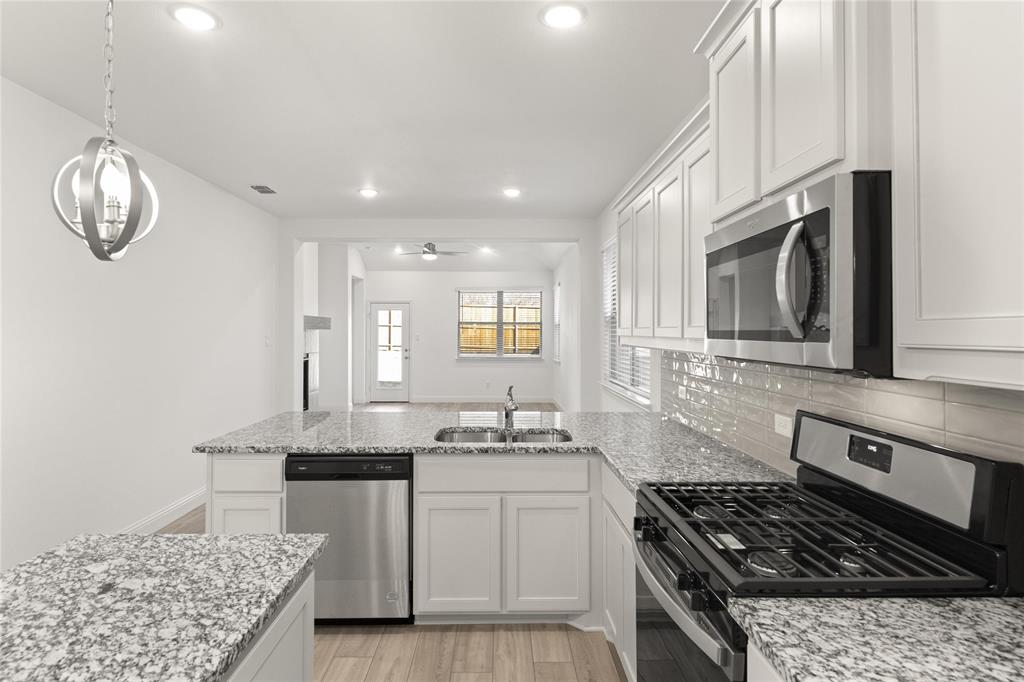 322 Boston Drive Princeton, TX 75407 - Photo 4 of 18 a kitchen with stainless steel appliances granite countertop a sink stove and cabinets