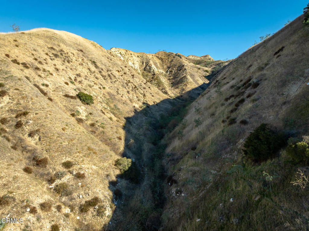 9701 Foothill Boulevard Lakeview Terrace, CA 91342 - Photo 17 of 51 a view of a dry yard with mountains in the background