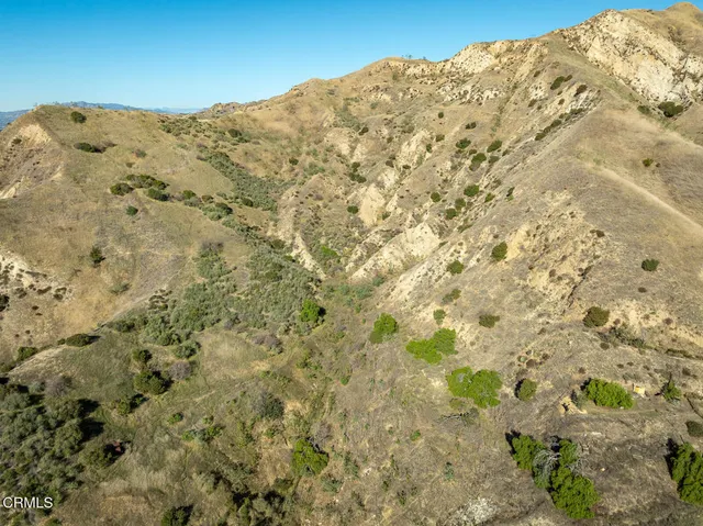 a view of a large mountain with white sky