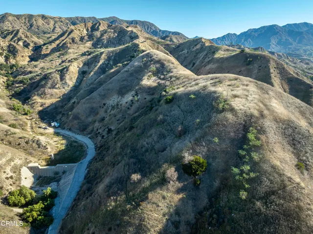 a view of a dry yard with mountains in the background