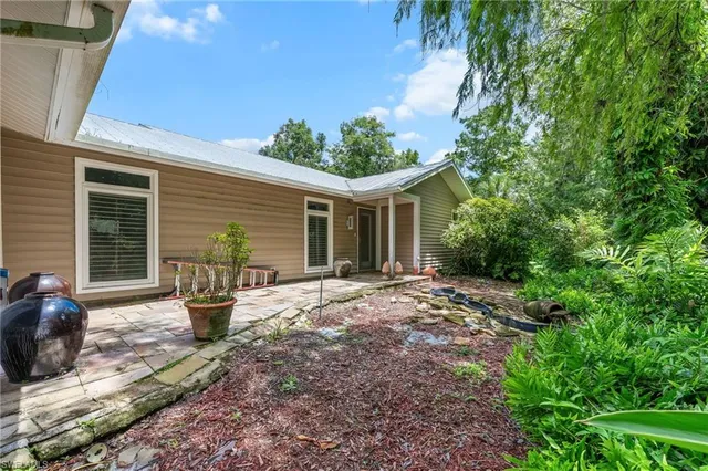 a view of a house with backyard sitting area and garden