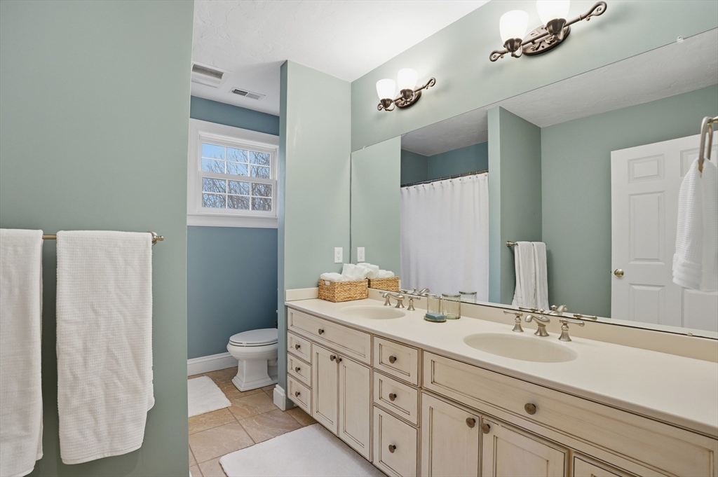 531 Salisbury Street Worcester, MA 01609 - Photo 26 of 42 a bathroom with double vanity sink a toilet and a mirror