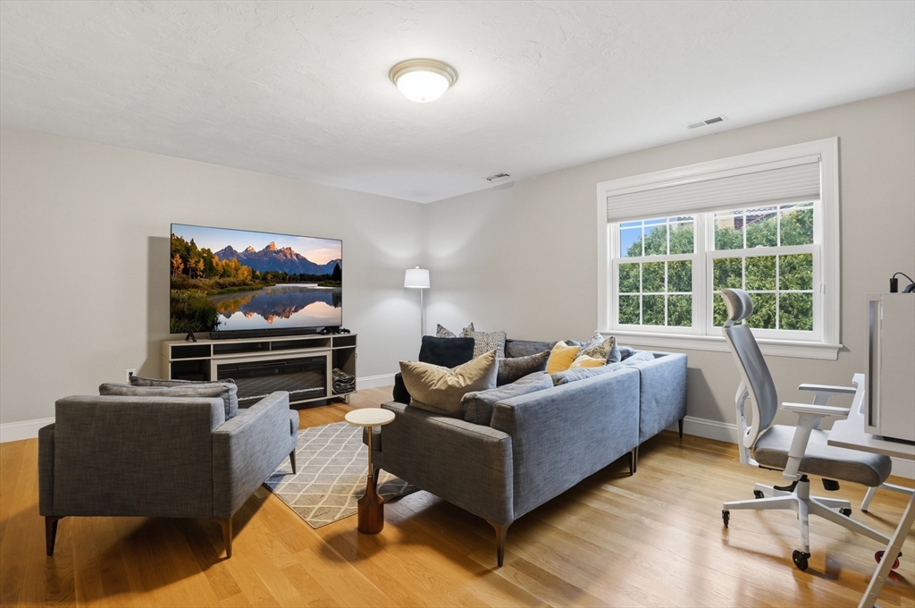 531 Salisbury Street Worcester, MA 01609 - Photo 29 of 42 a living room with furniture a flat screen tv and a floor to ceiling window