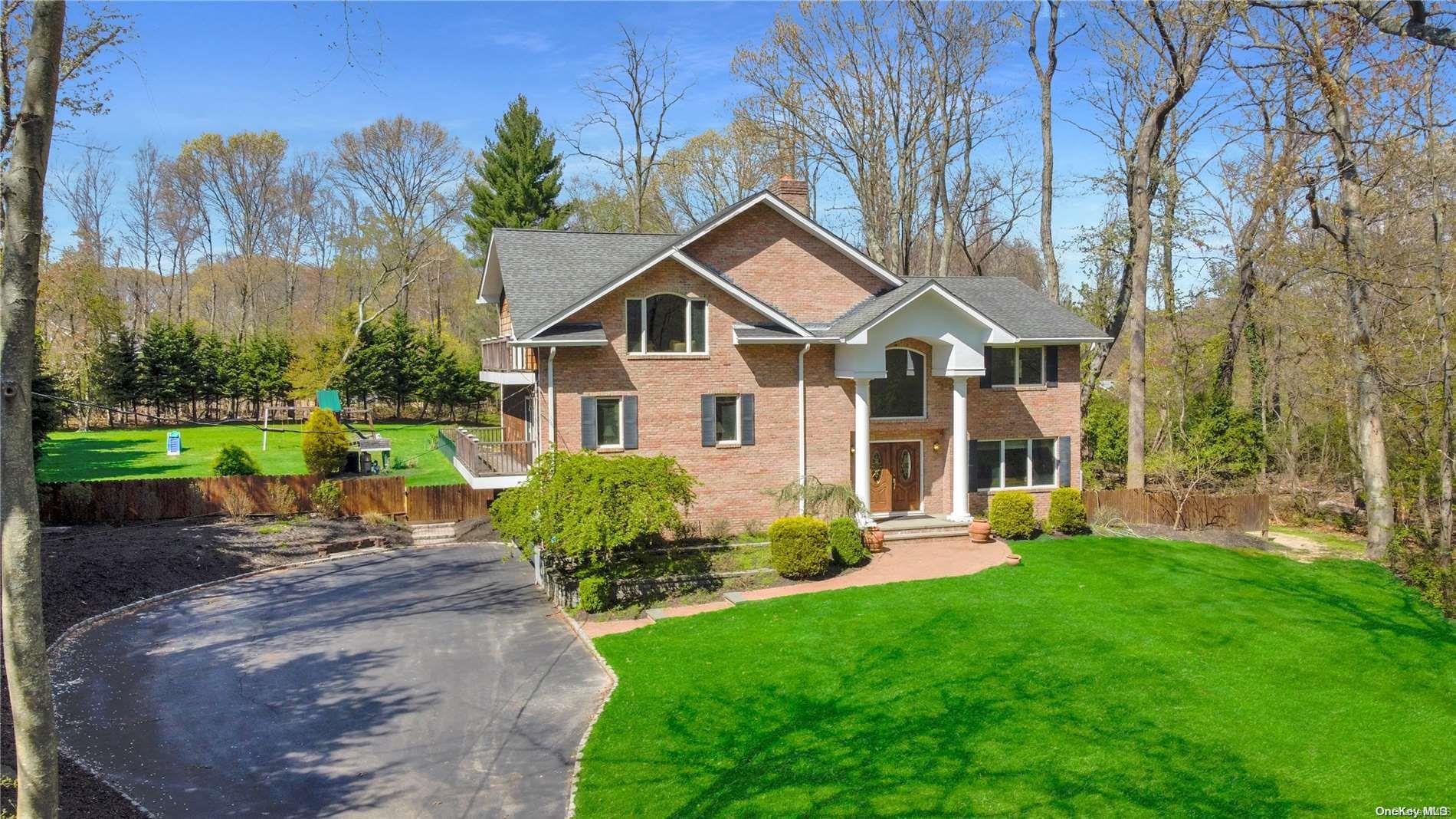 2 Woodhill Path Nissequogue, NY 11780 - Photo 1 of 1 a front view of a house with a yard and trees