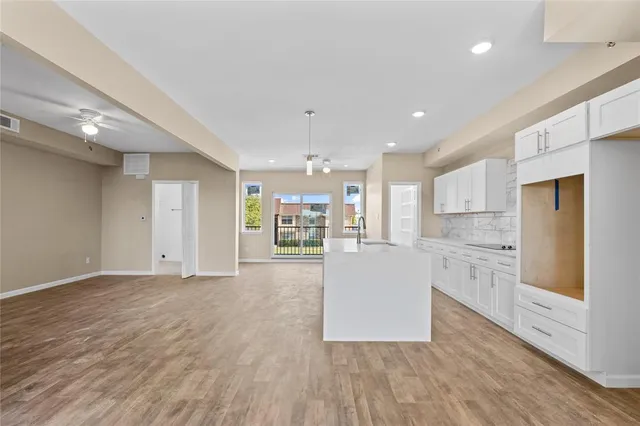 a large kitchen with cabinets wooden floor and a sink