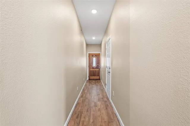 a view of a hallway with wooden floor
