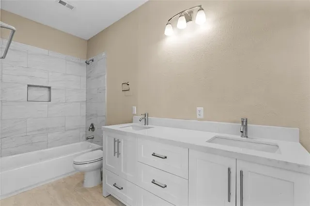 a bathroom with a toilet a sink a tub and mirror