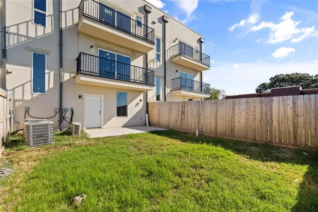 a view of a house with backyard and wooden fence