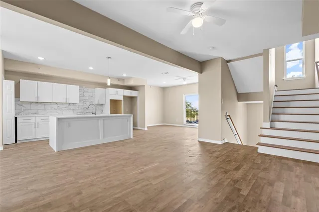 a view of a kitchen with kitchen island wooden floor and ceiling window