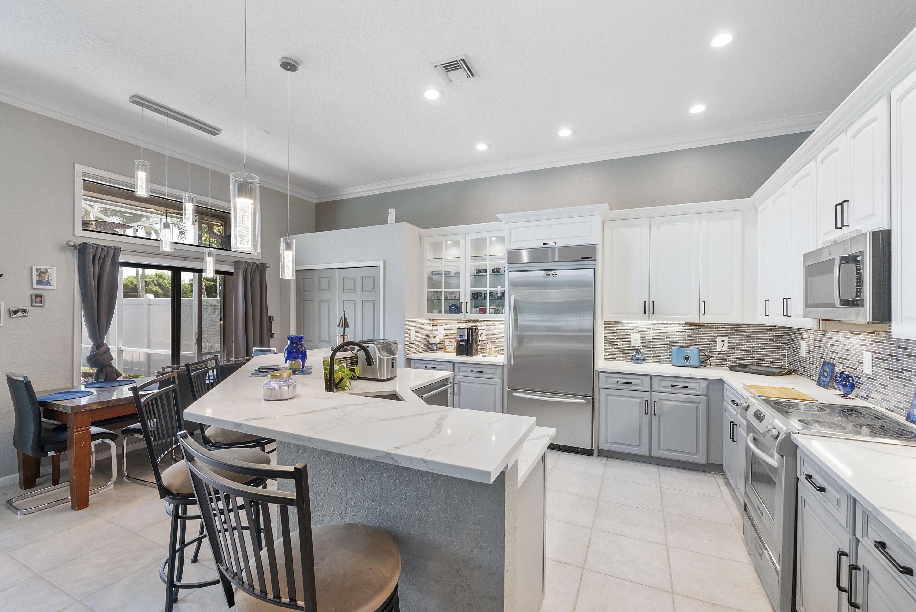 12328 St Simon Drive Boca Raton, FL 33428 - Photo 10 of 52 a kitchen with stainless steel appliances kitchen island granite countertop a sink and cabinets
