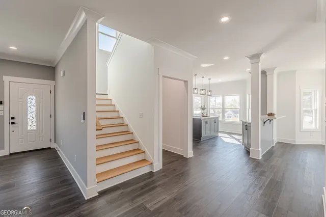 a kitchen with a sink a stove a refrigerator and white cabinets