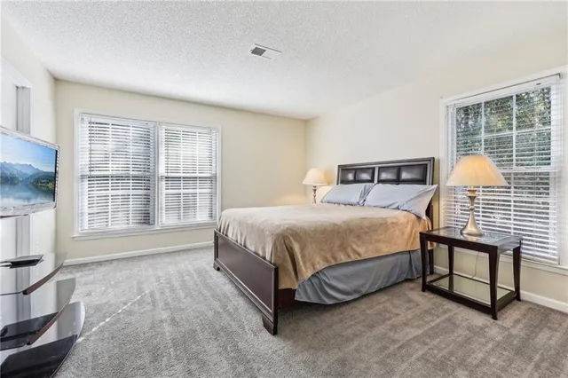 a spacious bedroom with a bed and a window