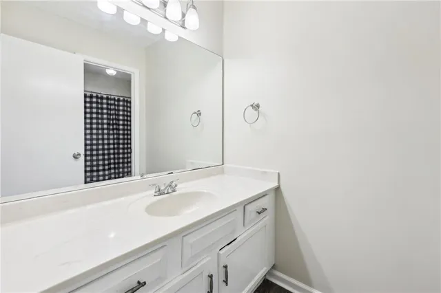 a bathroom with a sink vanity granite and a mirror