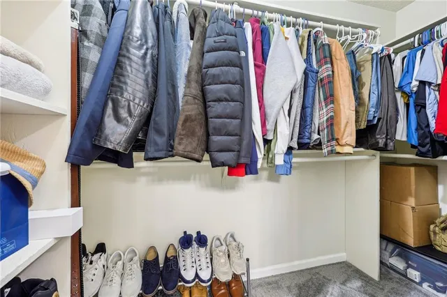 a view of walk in closet with clothes