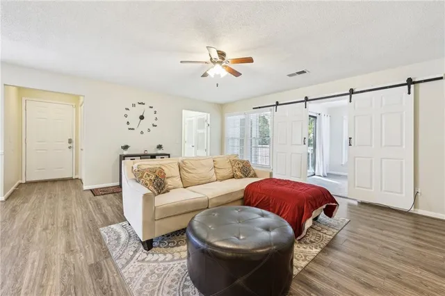 a living room with furniture a ceiling fan and a rug