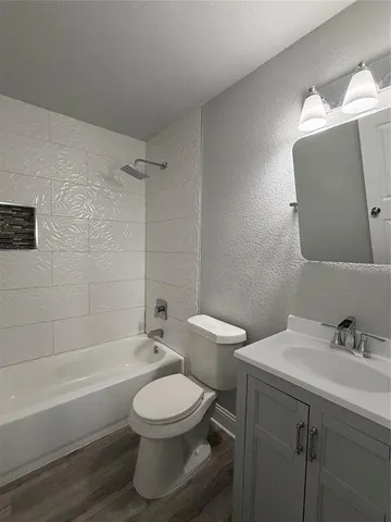 a bathroom with a toilet a sink a mirror and bathtub