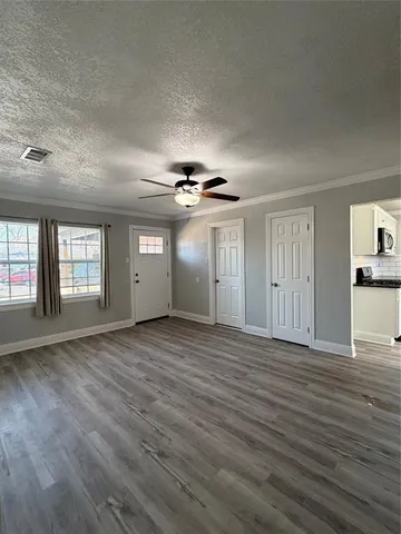 a view of an empty room with window and wooden floor