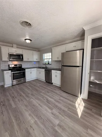 a kitchen with a refrigerator and a stove top oven