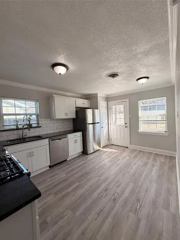 a large kitchen with stainless steel appliances granite countertop a stove and a refrigerator