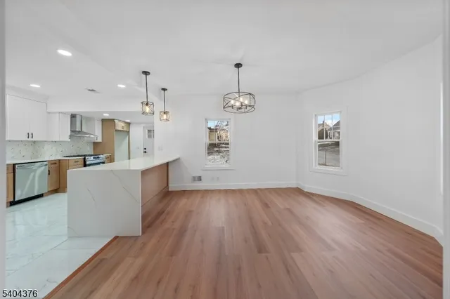 a view of a kitchen with wooden floor and windows