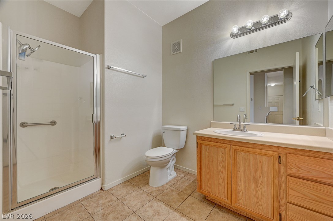 9050 West Warm Springs Road, Unit 1147 Las Vegas, NV 89148 - Photo 19 of 36 Functional full bathroom featuring a glass-enclosed shower, single vanity, and tiled flooring.