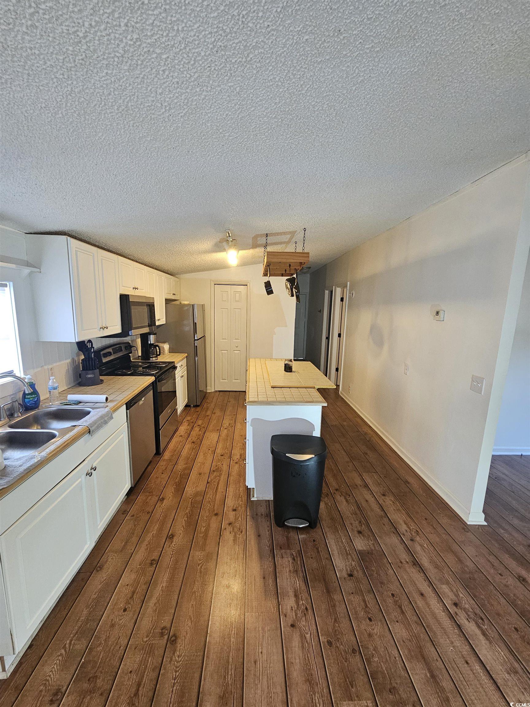 46 Islander Court Murrells Inlet, SC 29576 - Photo 3 of 14 Kitchen featuring a textured ceiling, dark wood-ty