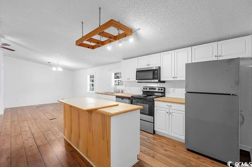 46 Islander Court Murrells Inlet, SC 29576 - Photo 4 of 14 Kitchen with ceiling fan, white cabinets, stainles
