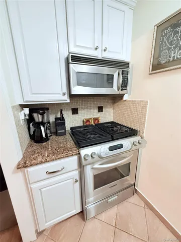 a kitchen with granite countertop white cabinets and white appliances