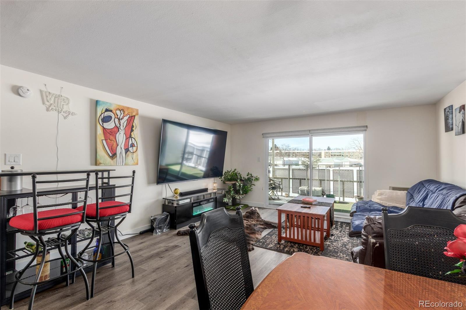 725 South Clinton Street, Unit 7B Denver, CO 80247 - Photo 12 of 29 a living room with furniture and a flat screen tv