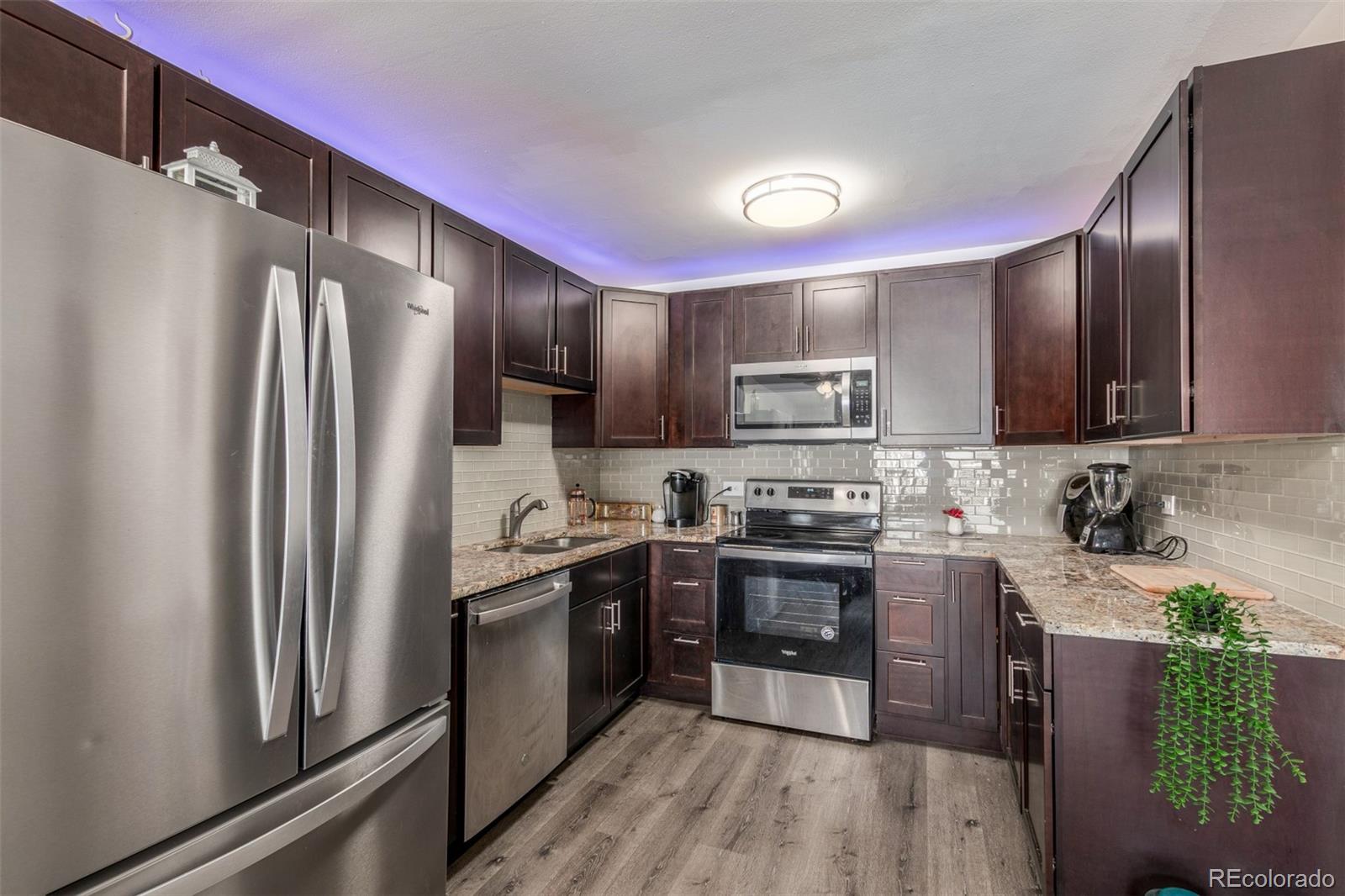 725 South Clinton Street, Unit 7B Denver, CO 80247 - Photo 13 of 29 a kitchen with stainless steel appliances granite countertop refrigerator a sink a stove a microwave and island