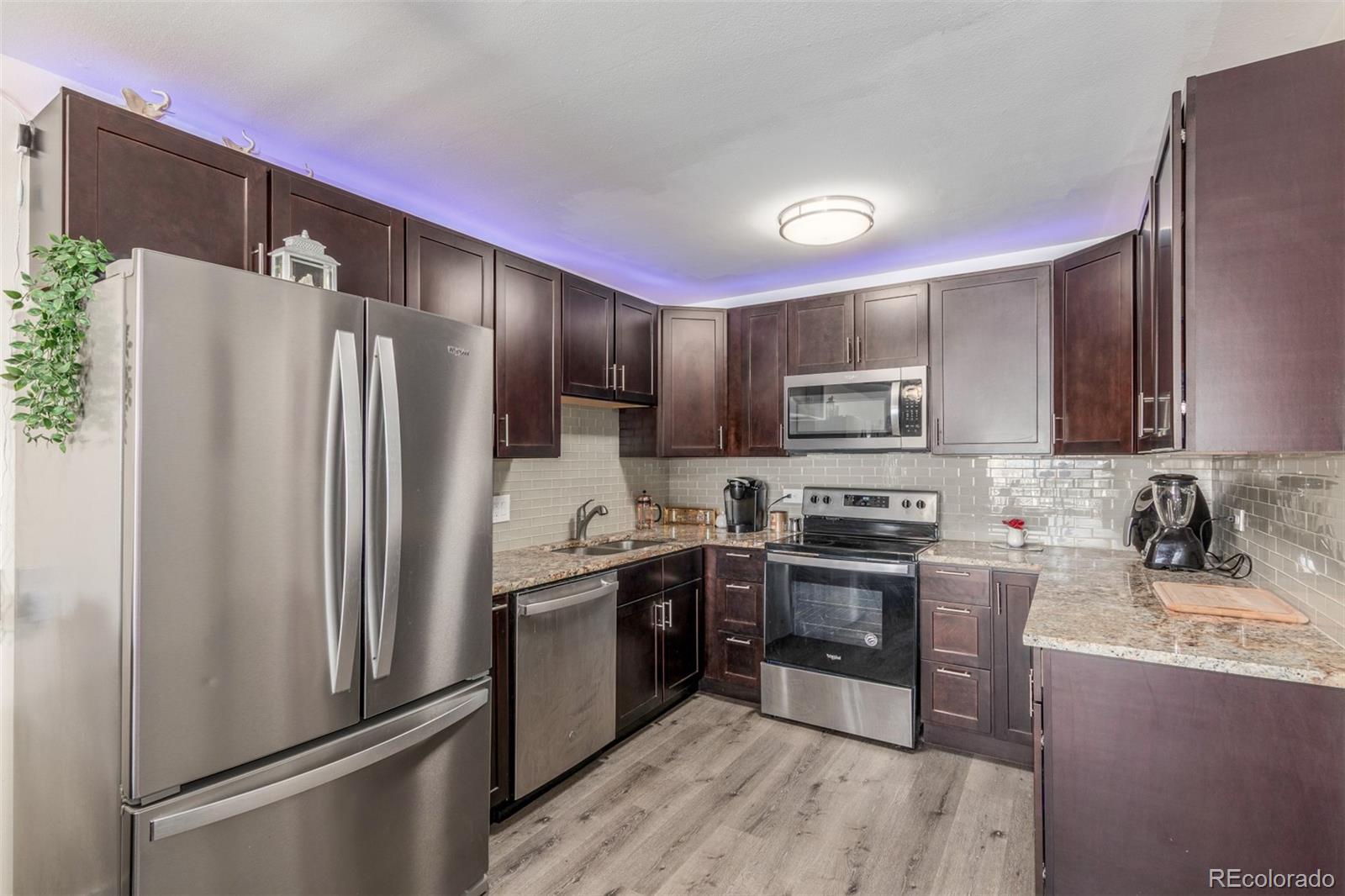 725 South Clinton Street, Unit 7B Denver, CO 80247 - Photo 16 of 29 a kitchen with stainless steel appliances granite countertop a refrigerator stove and sink