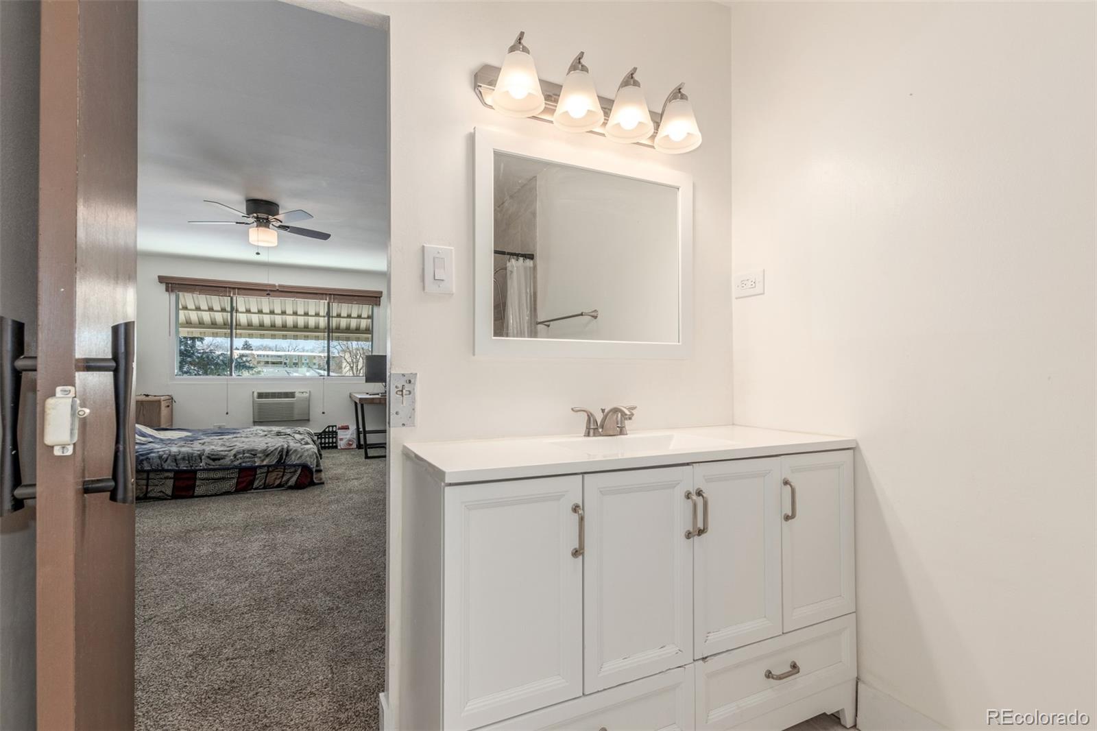 725 South Clinton Street, Unit 7B Denver, CO 80247 - Photo 20 of 29 a en suite bathroom with a toilet sink and mirror