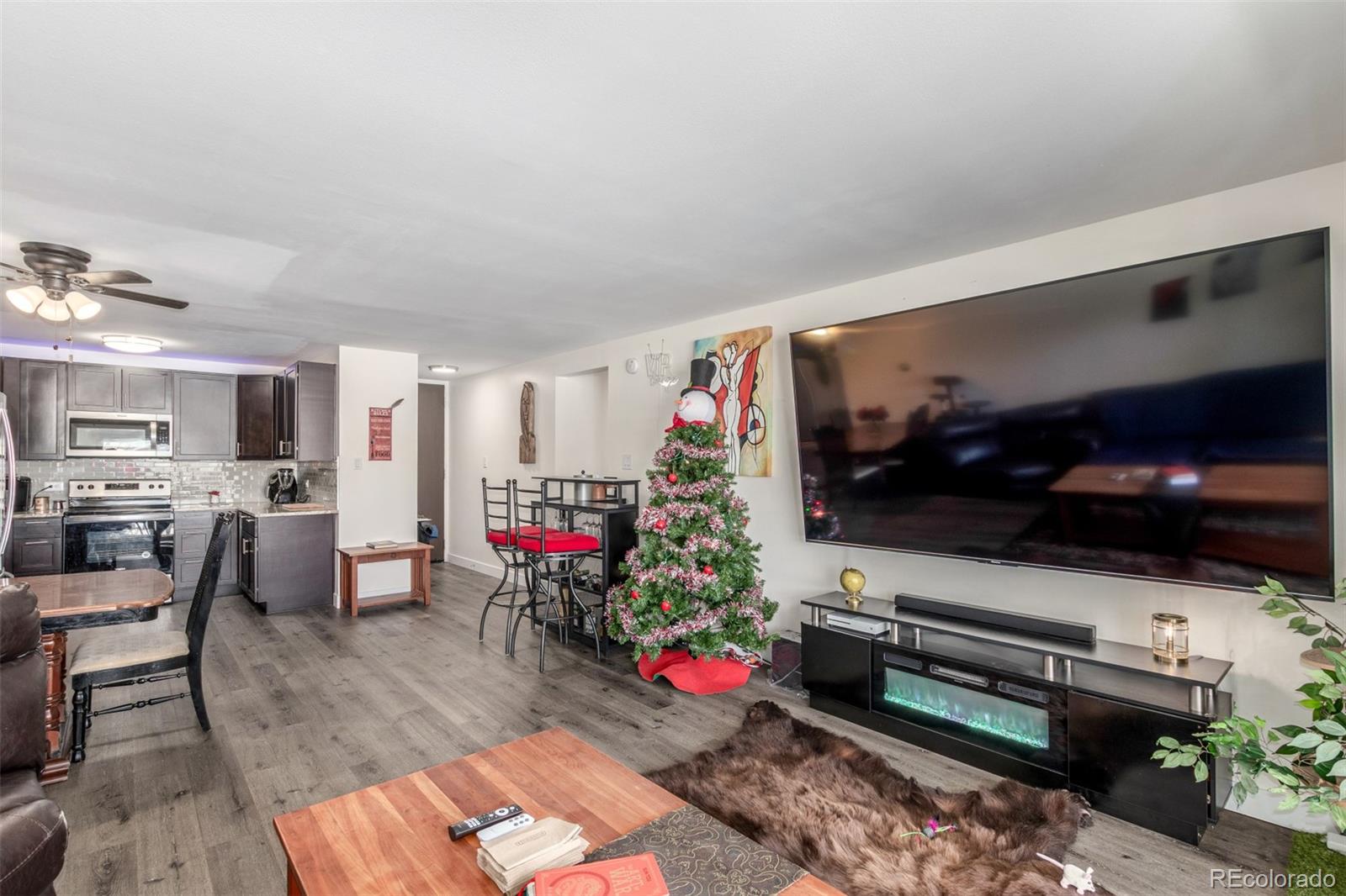 725 South Clinton Street, Unit 7B Denver, CO 80247 - Photo 7 of 29 a living room with furniture and a flat screen tv