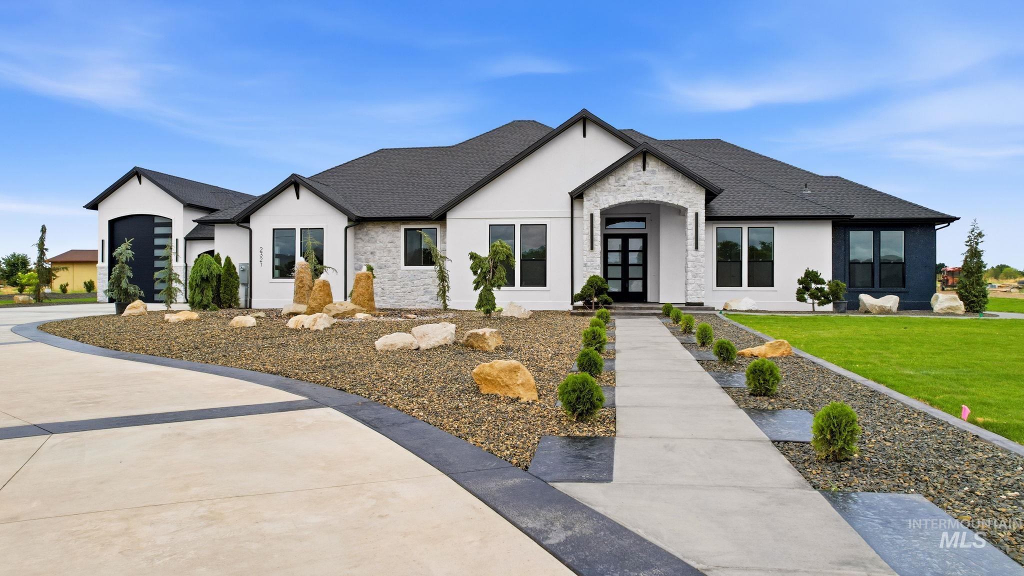 2321 Lower Bluff Road Emmett, ID 83617 - Photo 28 of 31 Covered back patio featuring arched supports, dark shingle roofing, and contemporary black-framed windows