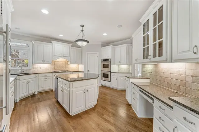 a kitchen with stainless steel appliances granite countertop a stove oven and a sink