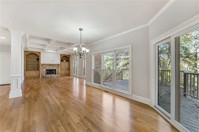 a view of a big room with wooden floor a chandelier and a living room