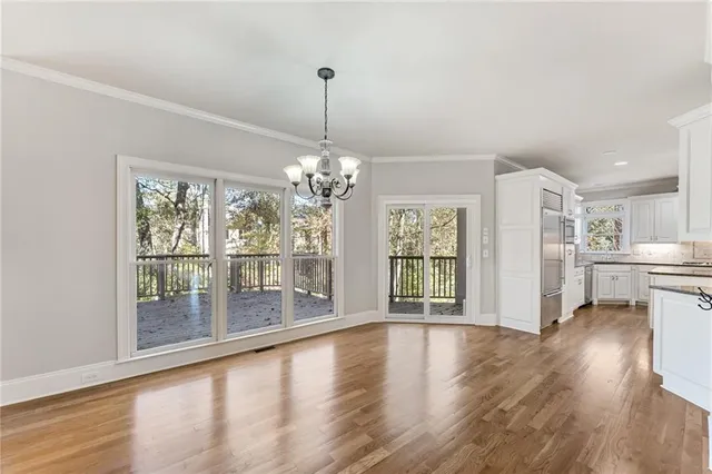 a view of a big room with wooden floor and windows