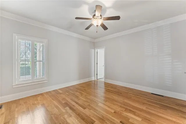 a view of an empty room with a window and a chandelier fan