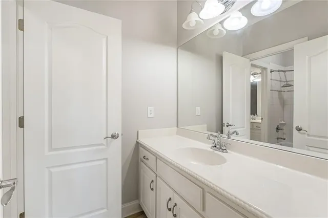 an empty room with a chandelier fan and windows