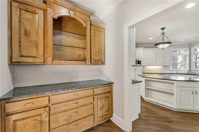 a kitchen with granite countertop white cabinets and white appliances