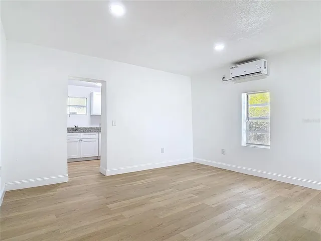 an empty room with a window and wooden floor