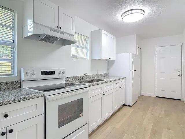 a kitchen with granite countertop cabinets stainless steel appliances and a counter space