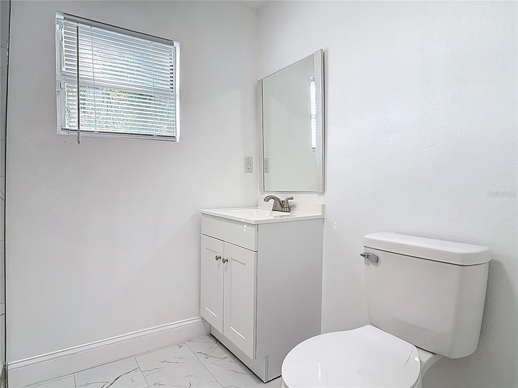 2410 SW Road Sanford, FL 32771 - Photo 20 of 30 a bathroom with a toilet a sink a vanity and mirror