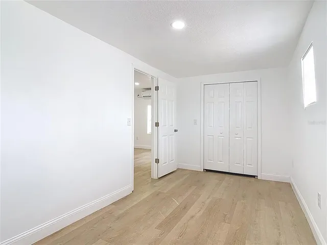 an empty room with a window and a ceiling fan