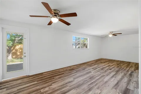 a view of a livingroom with wooden floor and a ceiling fan