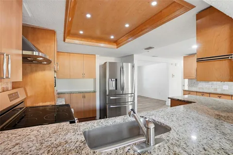 a kitchen with granite countertop sink stove and cabinets