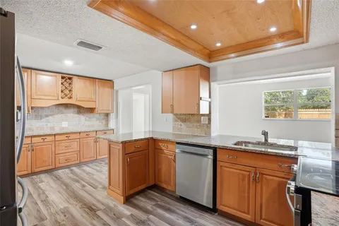 a kitchen with stainless steel appliances kitchen island granite countertop a stove a sink and a refrigerator