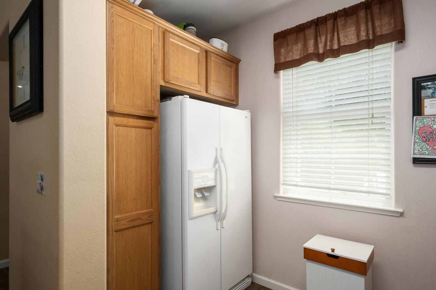 454 Sierra Avenue Reedley, CA 93654 - Photo 14 of 25 a white refrigerator freezer and a stove sitting inside of a kitchen