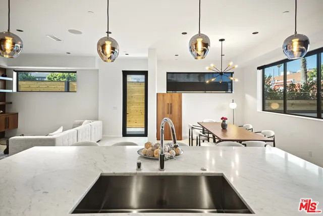 a kitchen with a dining table chairs and a chandelier
