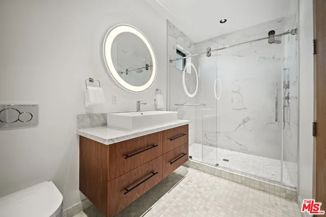 a bathroom with a sink a toilet and a mirror